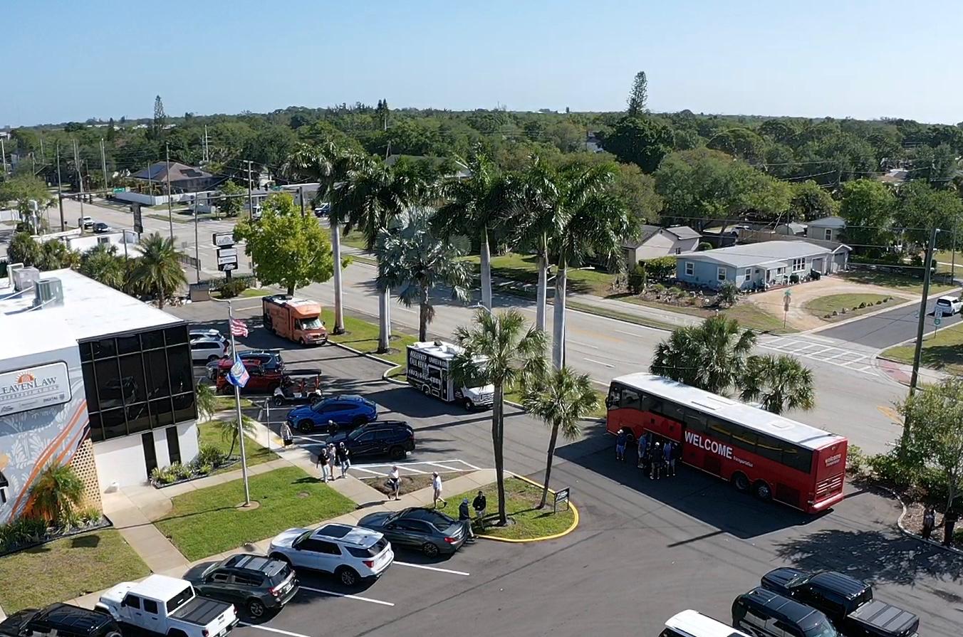 Aerial view of a Welcome Transportation bus picking up a group in a downtown parking lot