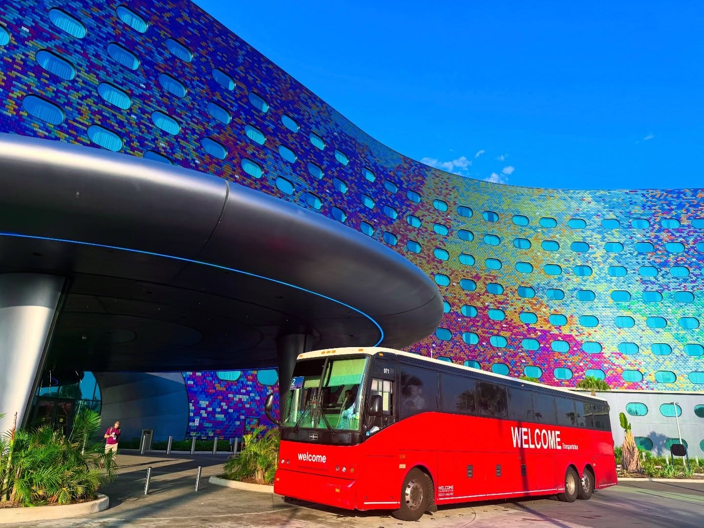 Welcome Transportation bus outside a resort with a colorful mosaic facade