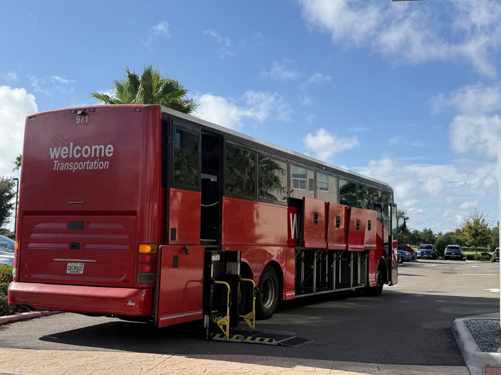 Red Welcome Transportation coach 971 with its wheelchair lift deployed